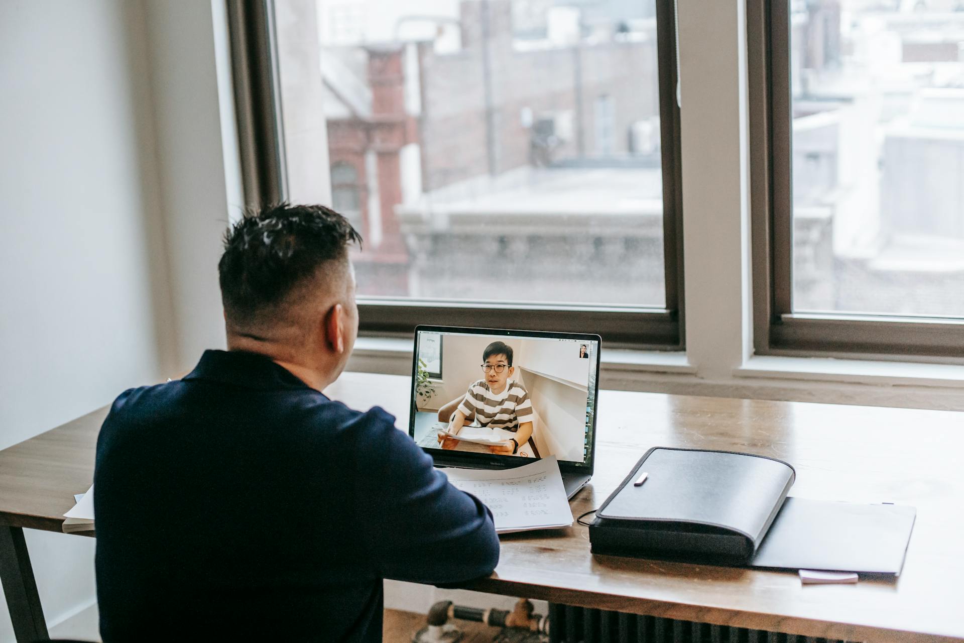 A lawyer questioning witness in a remote legal deposition via a laptop.